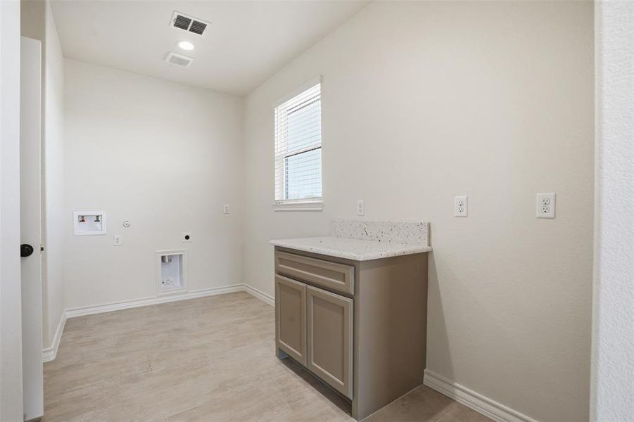 Laundry room featuring electric dryer hookup, hookup for a washing machine, hookup for a gas dryer, and cabinet space Laundry room featuring electric dryer hookup, hookup for a washing machine, hookup for a gas dryer, and cabinet space