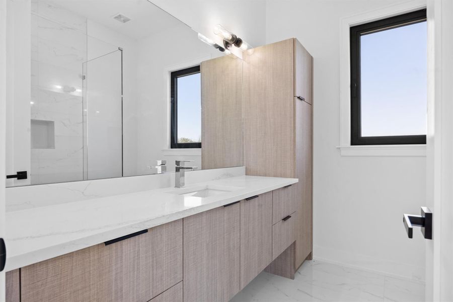 Bathroom featuring vanity, visible vents, baseboards, a marble finish shower, and marble finish floor