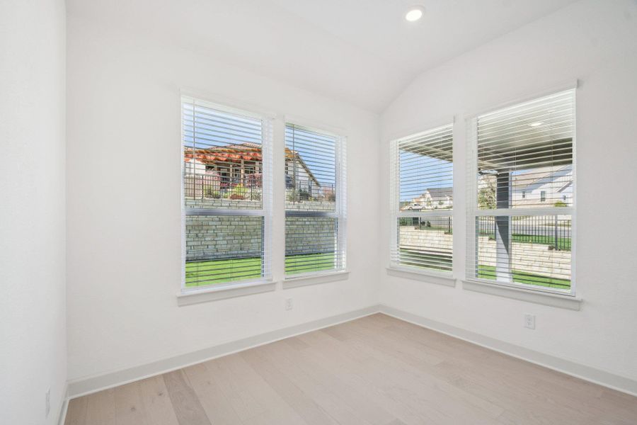 Spare room with light wood finished floors, vaulted ceiling, and recessed lighting Spare room with light wood finished floors, vaulted ceiling, and recessed lighting