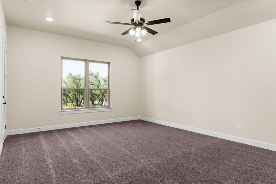Spare room featuring dark carpet, lofted ceiling, and ceiling fan Spare room featuring dark carpet, lofted ceiling, and ceiling fan