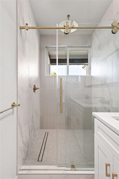 Full bathroom with vanity and a marble finish shower