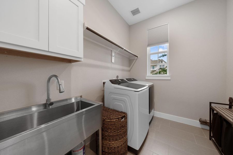 The laundry area is thoughtfully placed just off the kitchen, offering unmatched convenience for daily chores. Featuring a utility sink for added functionality. The laundry area is thoughtfully placed just off the kitchen, offering unmatched convenience for daily chores. Featuring a utility sink for added functionality.