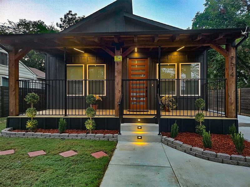 View of front of house featuring covered porch, board and batten siding, and a front yard