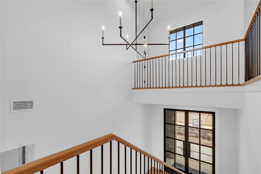 Staircase featuring a high ceiling and french doors Staircase featuring a high ceiling and french doors