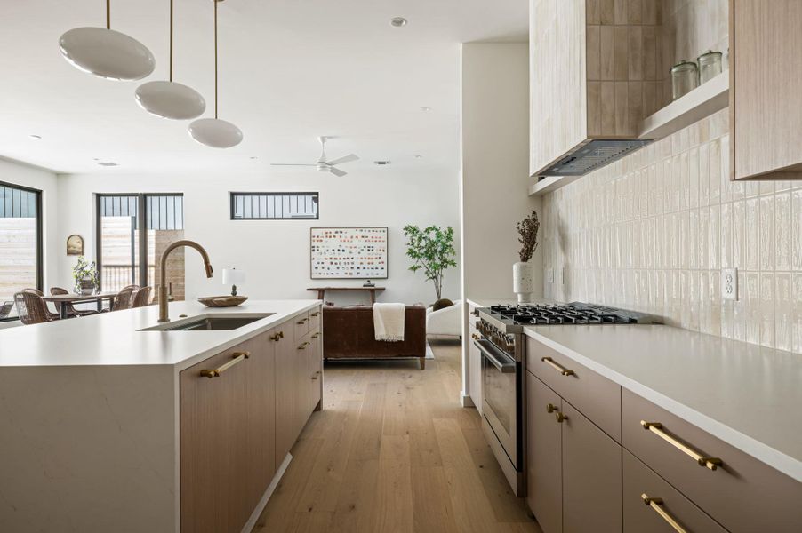 Gleaming stone countertops and warm wood flooring define this open concept kitchen design.