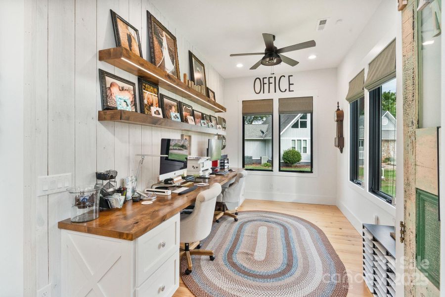 Main level office with open shelving adds warmth and farmhouse character Main level office with open shelving adds warmth and farmhouse character