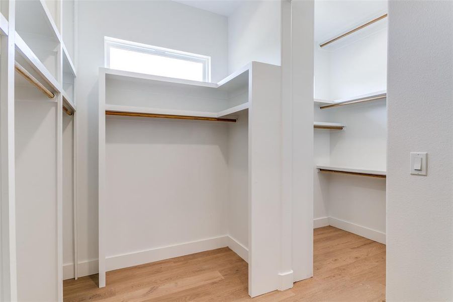 Walk in closet featuring wood finished floors Walk in closet featuring wood finished floors