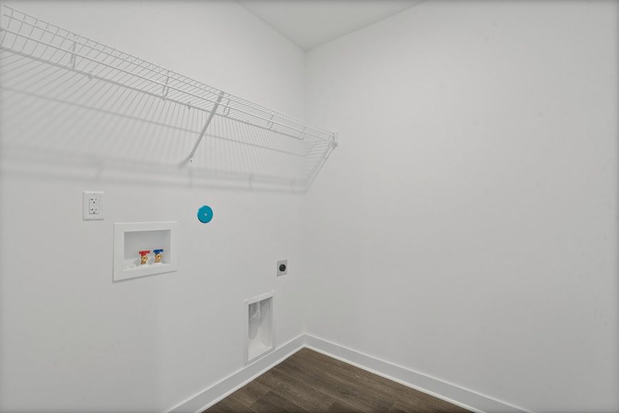 Laundry area with wood-finish flooring, white walls, and built-in wire shelving