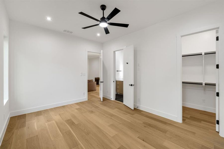 Bright interior space featuring wood-finish flooring, recessed lighting, and a contemporary ceiling fan