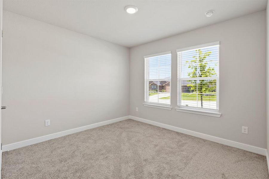 Room featuring neutral wall tones, two windows with white blinds, recessed ceiling lighting, and light-colored carpeting Room featuring neutral wall tones, two windows with white blinds, recessed ceiling lighting, and light-colored carpeting