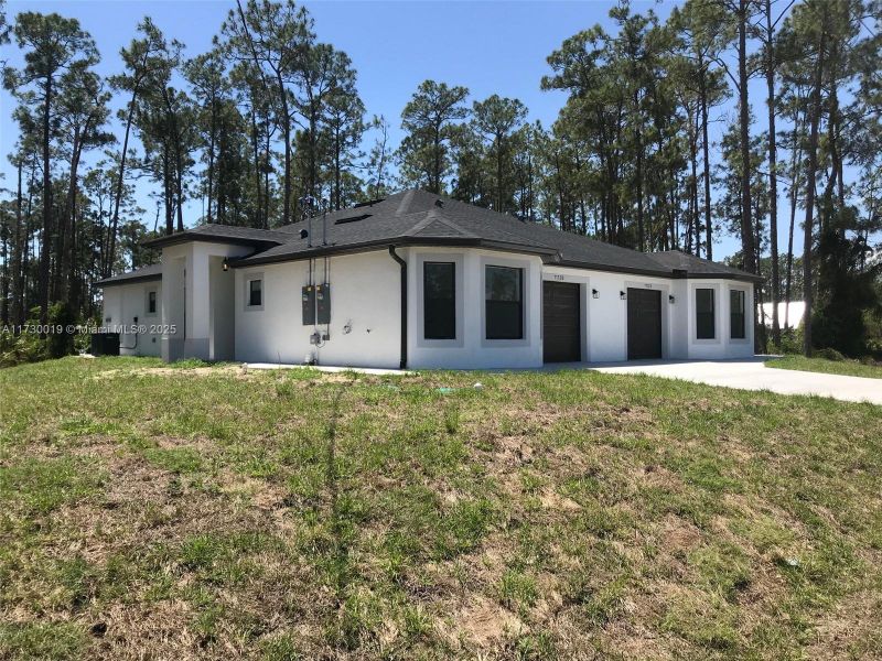 Front exterior of a new home in , Lehigh Acres, FL, highlighting curb appeal (Image 13).