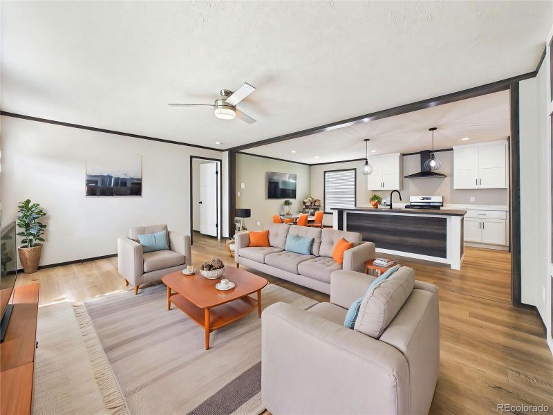 (Virtually Staged) – Staged living space illustrating layout potential with comfortable seating arrangement and a bright, welcoming atmosphere.