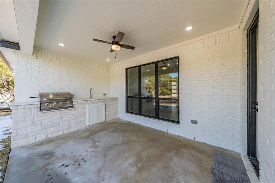 View of patio featuring area for grilling and ceiling fan