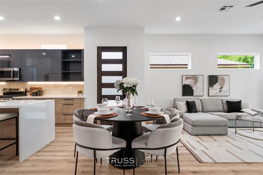 From the moment you step inside, natural light pours through wide picture windows, revealing an open-concept living space that feels both grand and grounded.