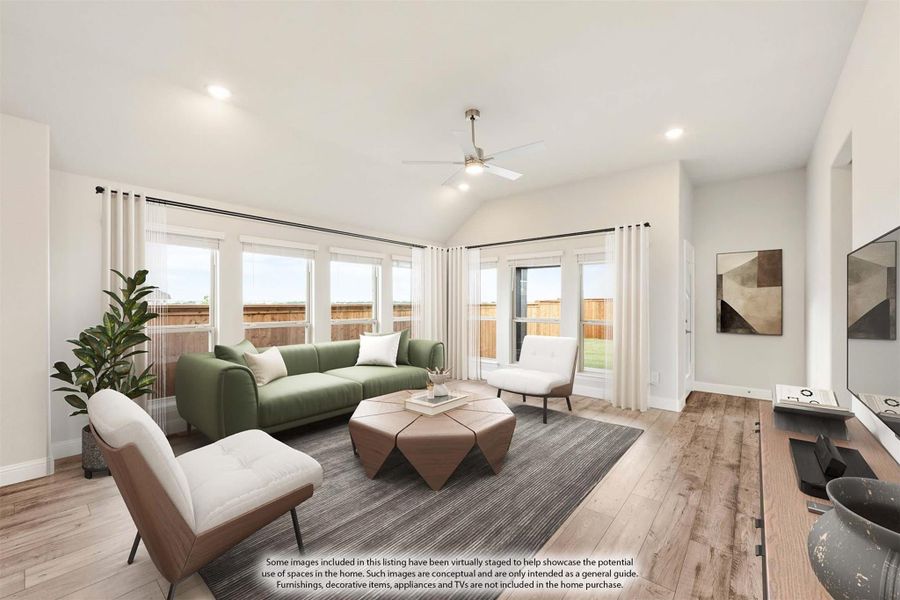 Living room with vaulted ceiling, ceiling fan, hardwood floors, and large windows with natural light Living room with vaulted ceiling, ceiling fan, hardwood floors, and large windows with natural light