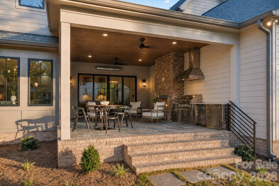 Extra large covered back porch with outdoor kitchen and dining area