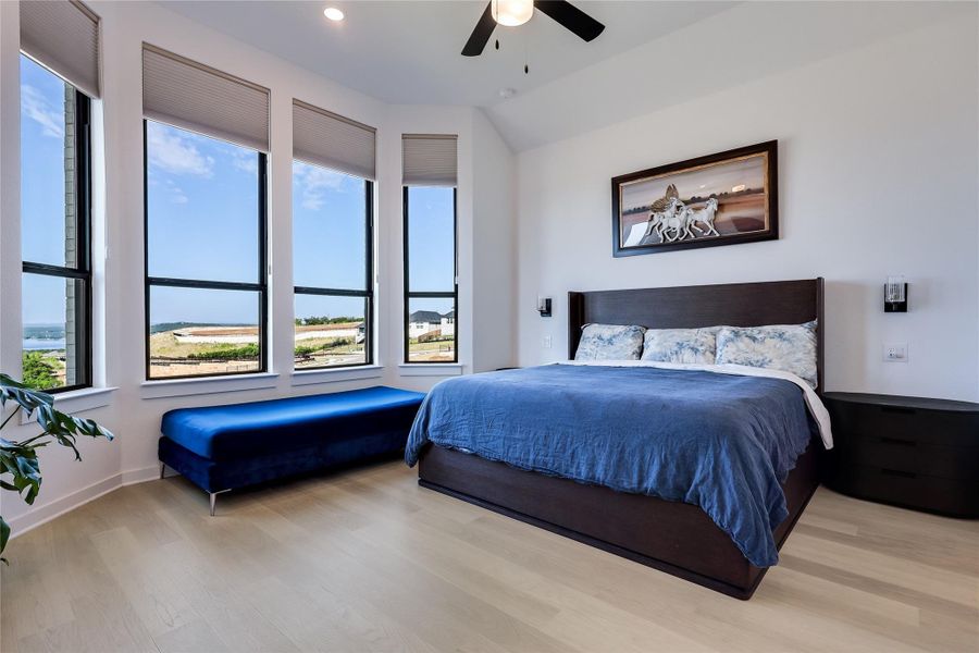 Towering windows frame distant neighborhood views in this light-filled bedroom with pale wood floors. Towering windows frame distant neighborhood views in this light-filled bedroom with pale wood floors.