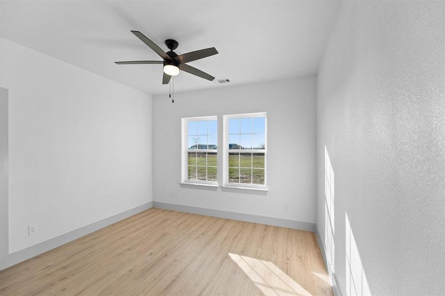 Spare room with light wood finished floors and a ceiling fan