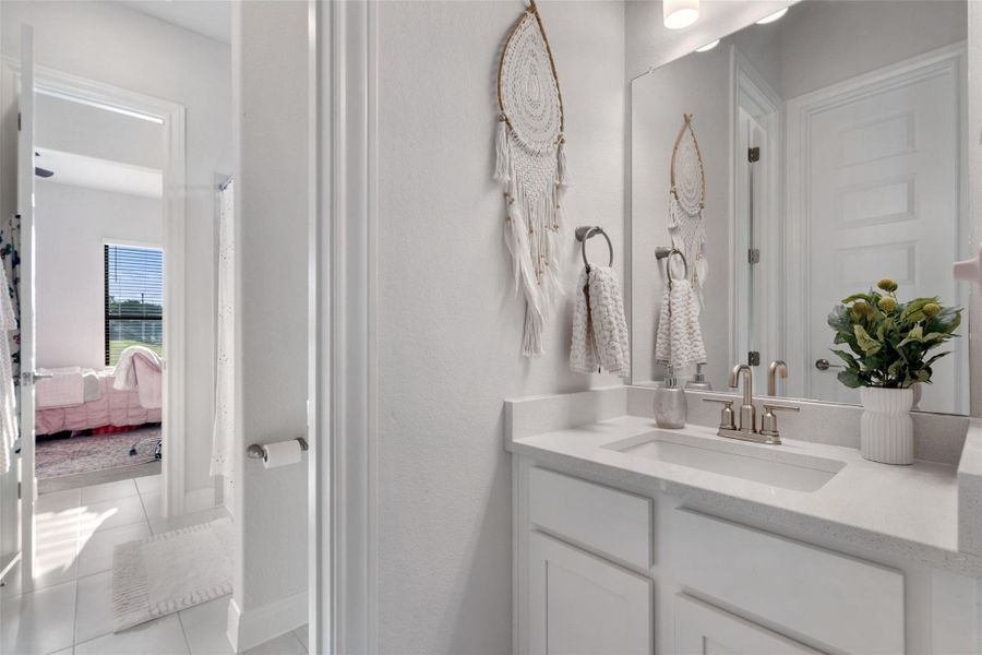A well-lit primary bathroom features a pristine white vanity with sleek countertops. A well-lit primary bathroom features a pristine white vanity with sleek countertops.