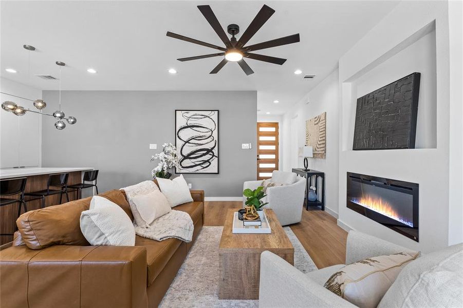 Living area with a glass covered fireplace, recessed lighting, and light wood-type flooring Living area with a glass covered fireplace, recessed lighting, and light wood-type flooring