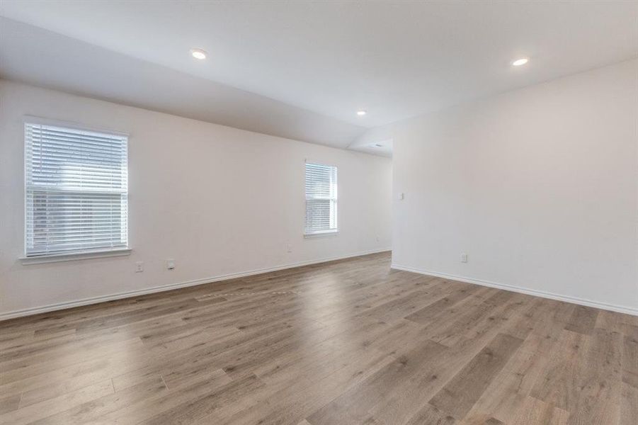 Unfurnished room with light wood-type flooring, vaulted ceiling, and recessed lighting Unfurnished room with light wood-type flooring, vaulted ceiling, and recessed lighting