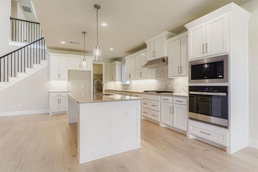 Kitchen featuring appliances with stainless steel finishes, decorative backsplash, white cabinets, and recessed lighting