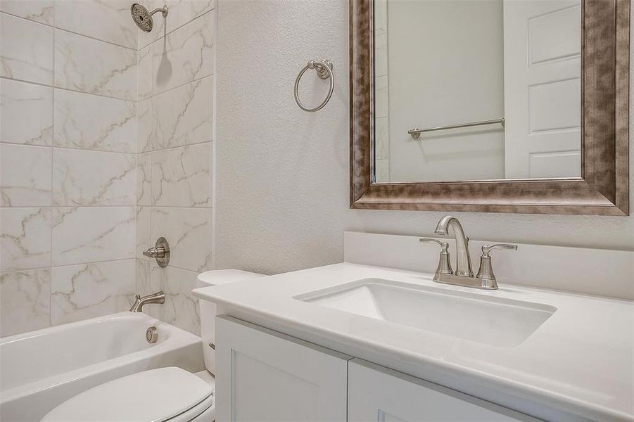 Full bathroom with toilet, vanity, and tiled shower / bath