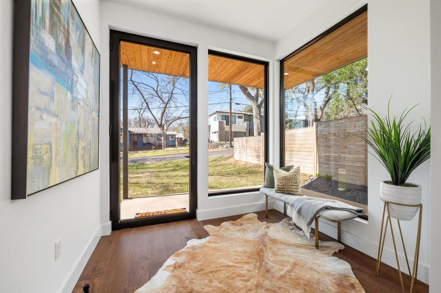 Living area with baseboards, wood finished floors, and a sunroom