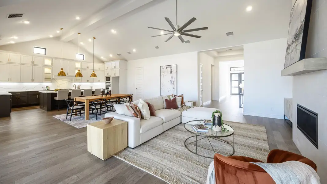Living area featuring visible vents, wood finished floors, a fireplace, high vaulted ceiling, and beam ceiling