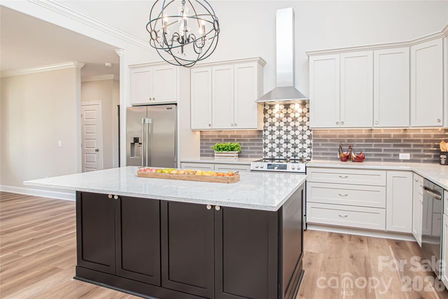 Warm white cabinets pair perfectly with the warm gray kitchen island, offering a tasteful and inviting contrast