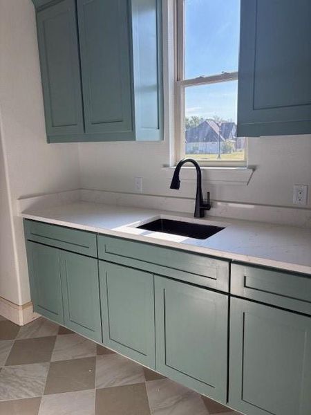 Kitchen with a sink and light stone countertops
