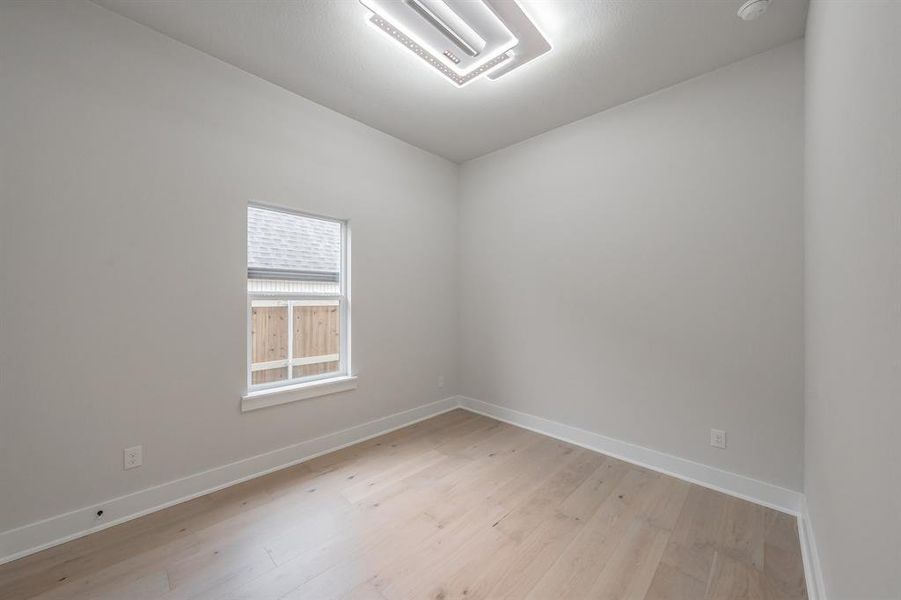 Unfurnished room with light wood-style flooring and baseboards