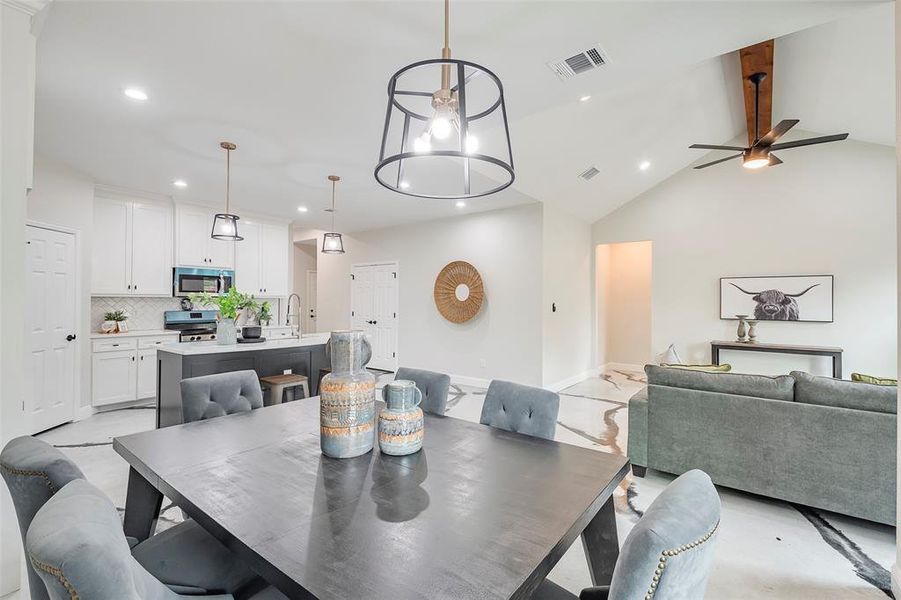 Dining room with high vaulted ceiling, sink, and ceiling fan