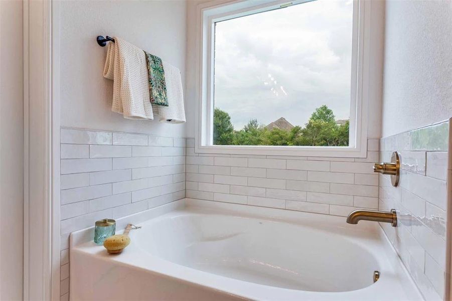 Bathroom featuring a bath and tile walls