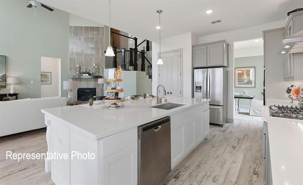 Expansive kitchen island with a white countertop, undermount sink, and integrated dishwasher