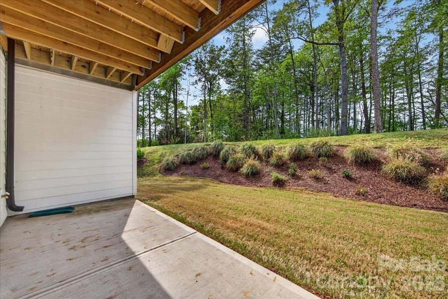 Private first floor covered outdoor living space with tree lined views