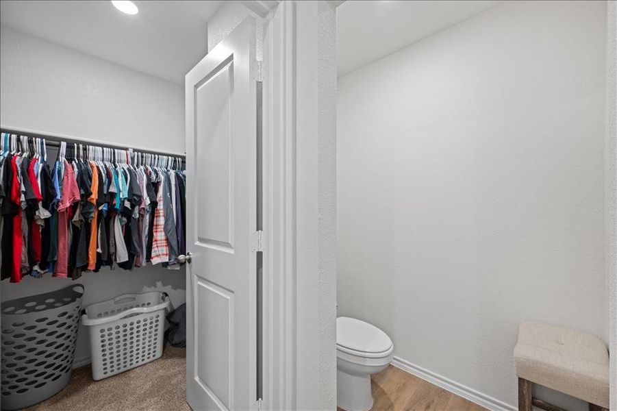 Bathroom featuring light wood-type flooring and a walk in closet Bathroom featuring light wood-type flooring and a walk in closet