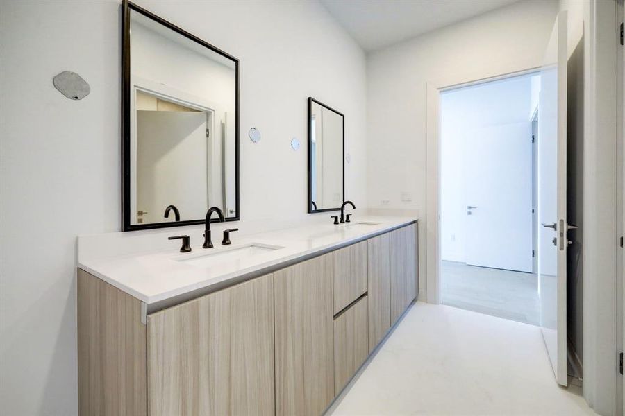 Secondary bathroom with double sinks, vanity and private shower and water closet.