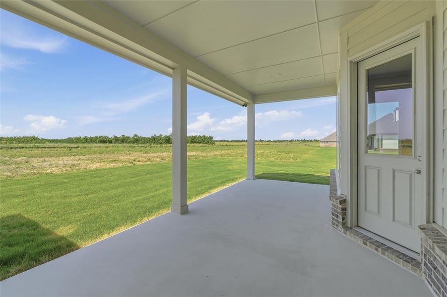 Covered patio featuring a concrete slab and white support columns Covered patio featuring a concrete slab and white support columns