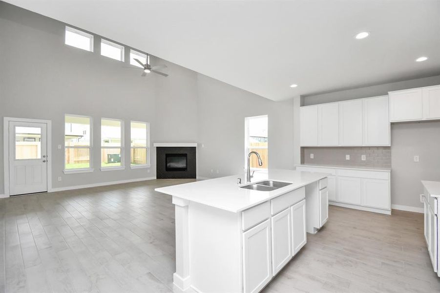 Step into a dream realized with this generously spacious kitchen! A massive granite island takes center stage, complemented by high ceilings and soft-close cabinets. The granite countertops, stainless steel appliances, sleek tile backsplash, and recessed lighting complete the elegant design.  Sample photo of completed home with similar plan. As built color and selections may vary.