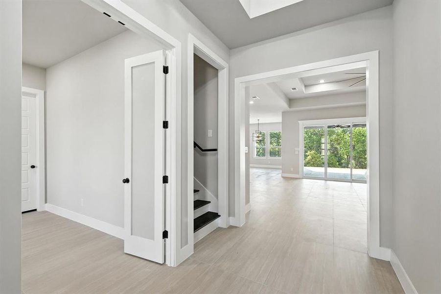 Hall with stairway, a raised ceiling, a skylight, light wood-style flooring, and recessed lighting Hall with stairway, a raised ceiling, a skylight, light wood-style flooring, and recessed lighting