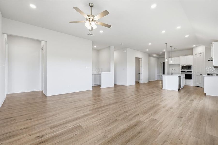 Unfurnished living room with a ceiling fan, recessed lighting, and light wood finished floors