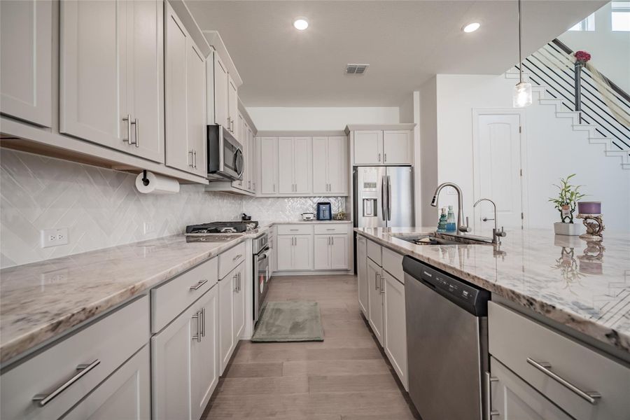 Culinary aspirations come alive in this kitchen, featuring luxurious countertops and modern appliances.