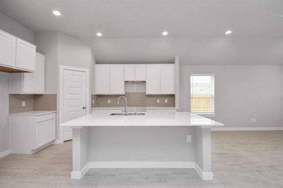 Discover another perspective of this stunning kitchen, generously appointed with an abundance of counter space. Sample photo of similar plan. As-built color and selections may vary.