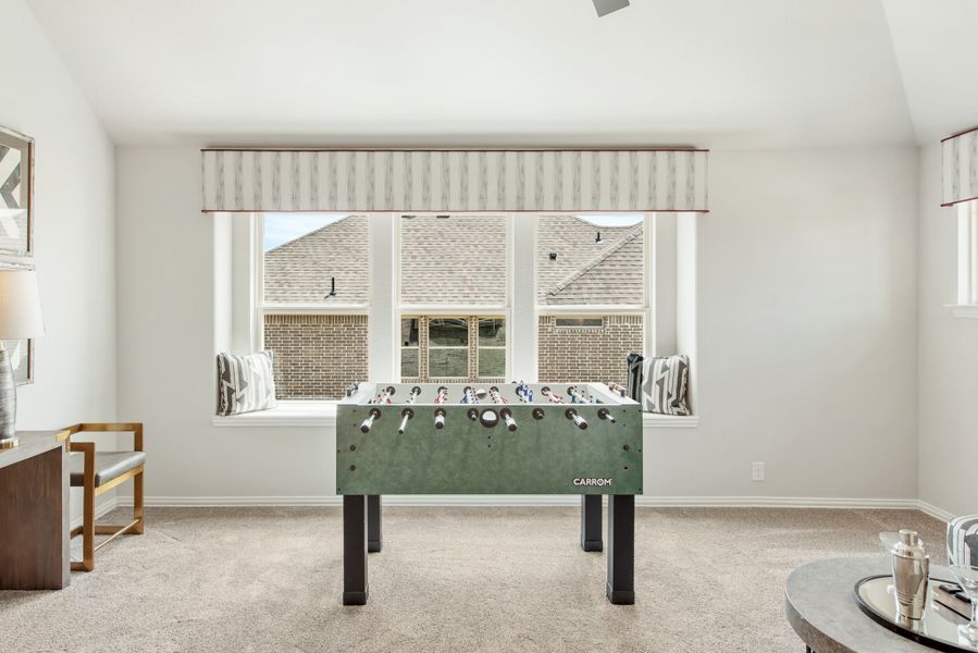 Game room with foosball table, window seat, and carpet flooring Game room with foosball table, window seat, and carpet flooring
