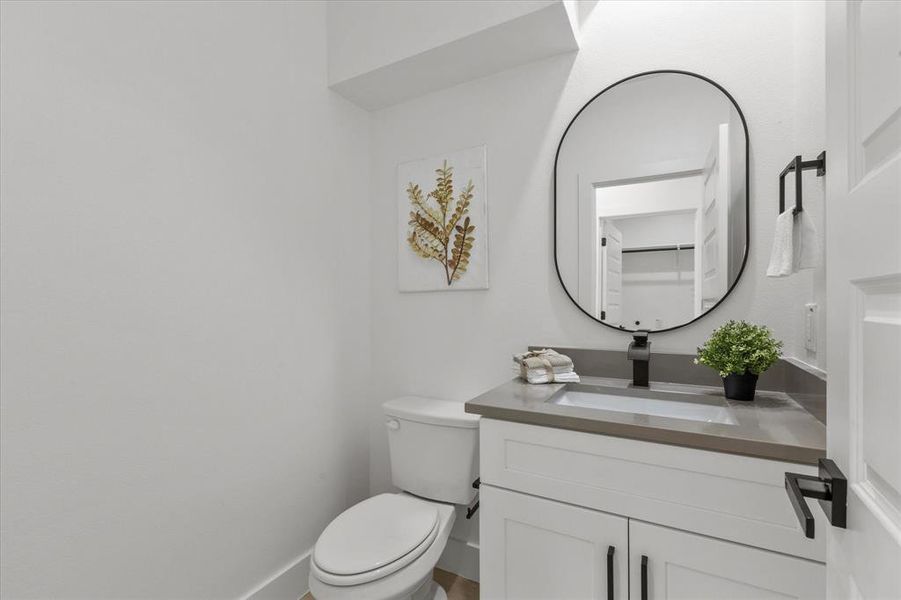 Half bath featuring vanity and toilet Half bath featuring vanity and toilet