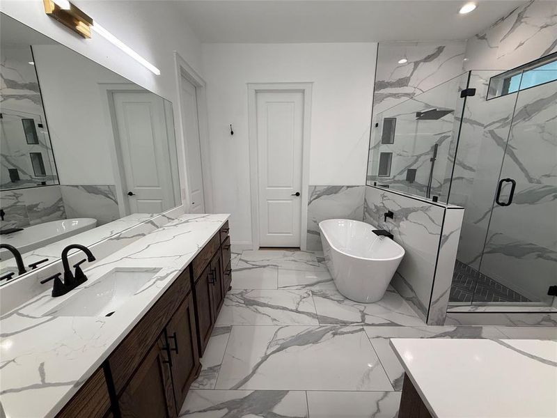 Full bathroom featuring a soaking tub, vanity, a marble finish shower, recessed lighting, and light marble finish flooring Full bathroom featuring a soaking tub, vanity, a marble finish shower, recessed lighting, and light marble finish flooring