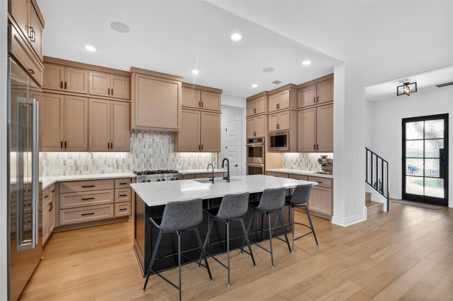 An inviting kitchen with a central island and light wood cabinetry, perfect for entertaining. An inviting kitchen with a central island and light wood cabinetry, perfect for entertaining.