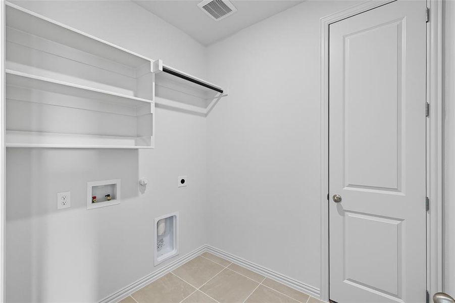 Washroom with light tile patterned flooring, gas dryer hookup, washer hookup, and electric dryer hookup Washroom with light tile patterned flooring, gas dryer hookup, washer hookup, and electric dryer hookup