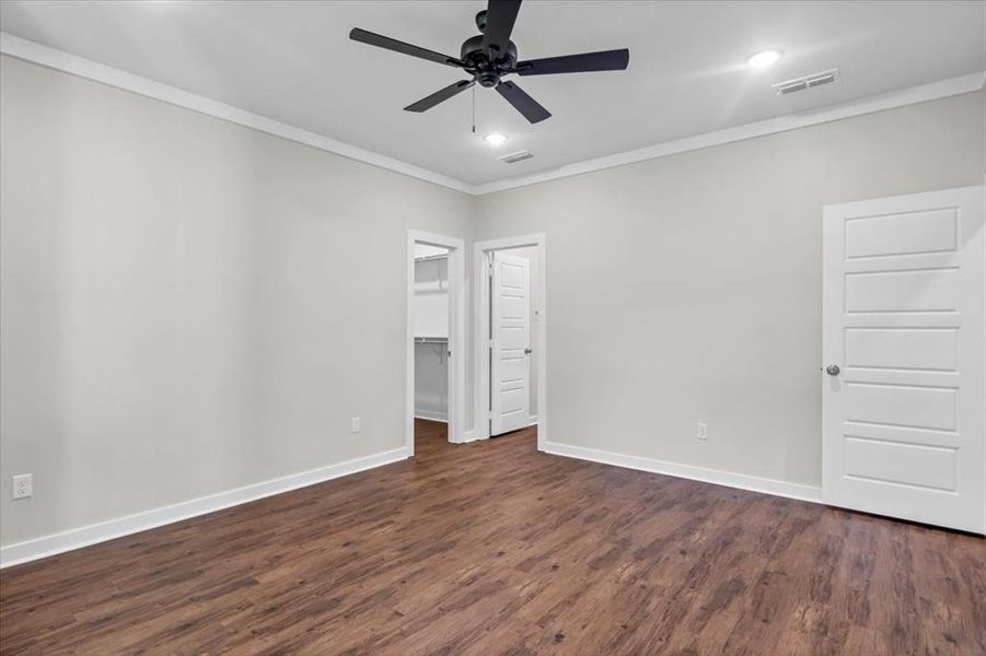 Unfurnished bedroom with crown molding, dark wood finished floors, baseboards, recessed lighting, and ceiling fan